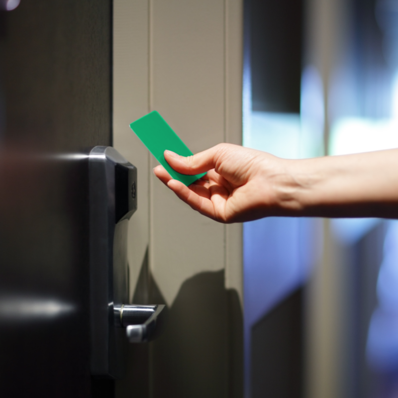 Locks: hand holding a green RFID key to door lock